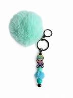 Porte-clés pompon turquoise avec figurine baby saja